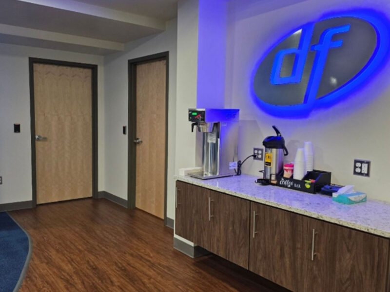 Hospitality counter and blue Dort Financial logo inside Clarkston Member Center | FUNArchitecture Hospitality counter and blue Dort Financial logo inside Clarkston Member Center