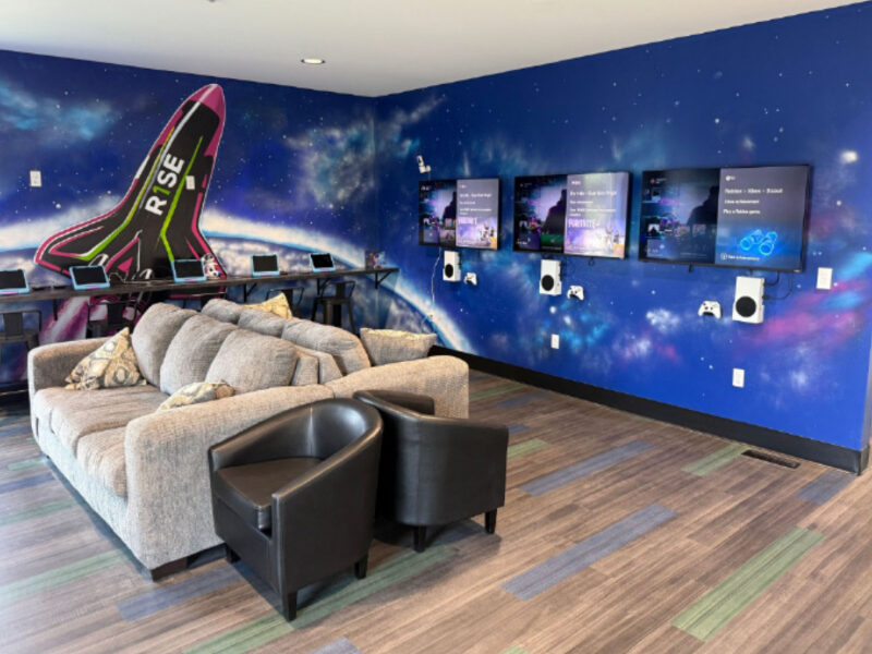 Lounge seating and space-themed wall art at R1SE in Frankenmuth